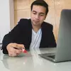 Jóven escribiendo en una mesa de vidrio