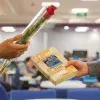 Un chico entregando una rosa y una chica entregando un libro