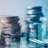 Imagen de monedas apiladas yuxtapuesta con imagen de gráficos financieros