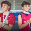 Dos jugadores de basquetbol posando con sus medallas del Nacional CONADEP en la Arena Borregos