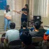 Estudiantes enseñando ciencia frente a un grupo. 