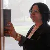 Directora de Mentoría de PrepaTec Laguna con vestimenta profesional toma libro de estante