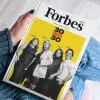 Manos de joven sosteniendo la portada de 30 Under 30 de Forbes México
