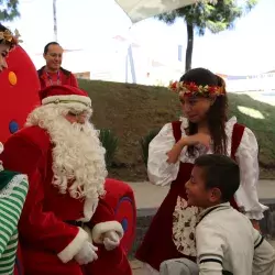 Niño acercándose a Santa Claus y duendes 