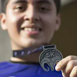 Reciben participantes medalla al finalizar la carrera.