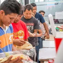 Migrantes con alimentos en las manos