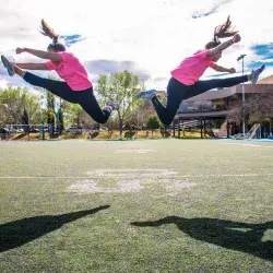 Dos mujeres haciendo acrobacias en una cancha de fútbol americano