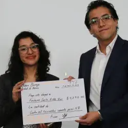 alumnos entregando cheque