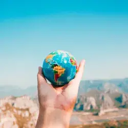Joven sosteniendo un globo terráqueo 