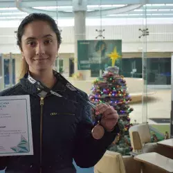 Corina con la medalla de bronce y diploma de la competencia