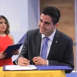 Estudiante Raul Maya de la carrera de Ingeniería Industrial firmando su título. 