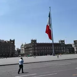 Vista del Zócalo de la Ciudad de México, con una persona caminando por su calle ante el vacío de vehículos