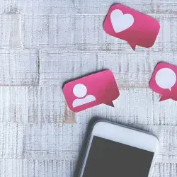 Teléfono celular con posts de likes, comentarios y seguidores.