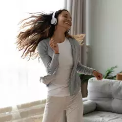 Chica feliz en casa escuchando música