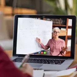 Estudiante toma una clase en línea y observa explicación de maestra