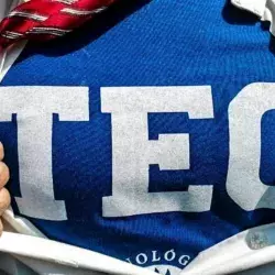 Persona que se abre la playera para poder apreciar la playera TEC de fondo.