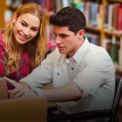 Alumno con discapacidad motriz y estudiante en biblioteca