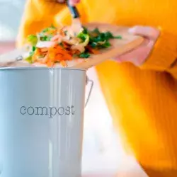 Mujer aprovechando los desechos vegetales de su cocina para hacer composta