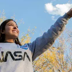 Carolina señalando el cielo con una sudadera de la nasa