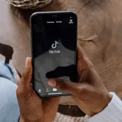 Persona abriendo aplicación de TikTok en su celular 