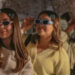 Tres adolescentes comprando lentes en el bazar.