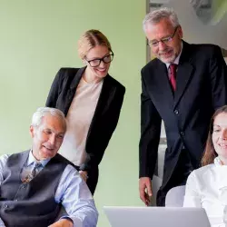 familia empresaria viendo laptop en reunion que busca trascendencia familiar