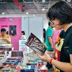 Chica joven en la Feria del Libro Monterrey, con el libro El 