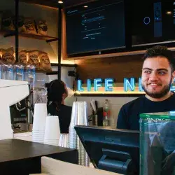 Persona siendo atendida en un negocio de café 