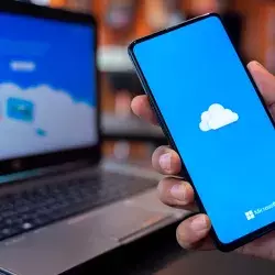 Celular y computadora con el logo de la herramienta OneDrive