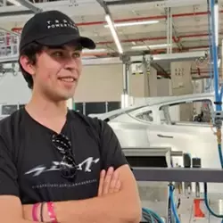 Estudiante posando para una foto en una planta automotriz