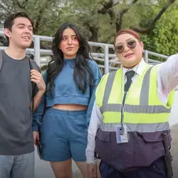 Guardia de seguridad ayudando a dos estudiantes