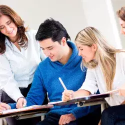 Profesora interactuando con un grupo de 4 alumnos