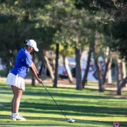 Jugadora preparando su tiro en uno de los hoyos del recorrido.