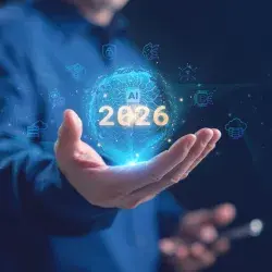 Un hombre de negocios sosteniendo un globo de IA holográfica brillante con 2026 e inteligencia artificial, computación en la nube, red neuronal e iconos de ciberseguridad, que representan la tecnología futura. Tendencias de la IA en 2026.