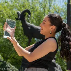 Alumna sosteniendo premio.