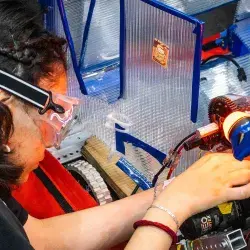 Estudiante de prepatec arreglando robot en FIRST