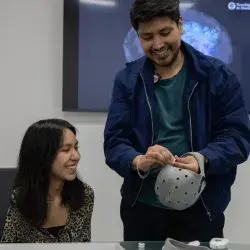 Un profesor del Tec CCM ajustando un casquete de electroencefalograma (EEG) en la cabeza de un estudiante dentro del MKT Research Lab.