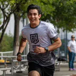 Alumno sonriente corriendo en atletismo