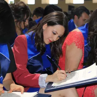 alumna firmando título