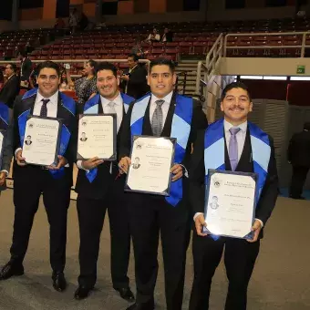 alumnos posando con su título