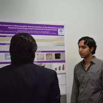 Marcelo Martínez presentando su poster al profesor Rogelio Soto y Adriana Canseco