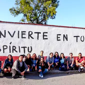 Alumnos y Armando Alanís pintando paredes con frases poéticas