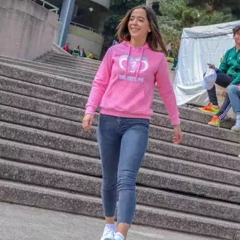 Chica modelando en pasarela sudadera rosa con bordado tec