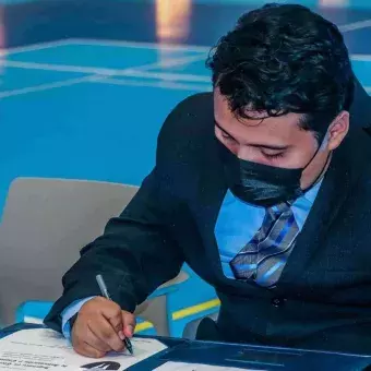 Alumno firmando su título profesional.