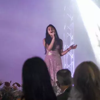 Alumna cantando en evento de graduación