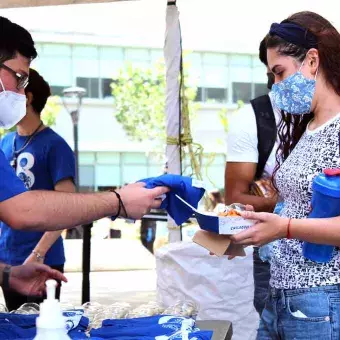 Alumno entregando playera del 78 Aniversario del Tec