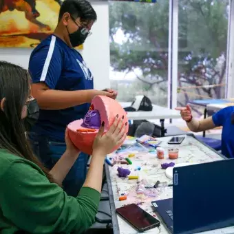 Alumnos pintando una escultura