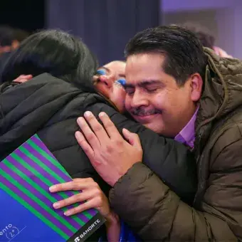 Padres de familia abrazando a su hija