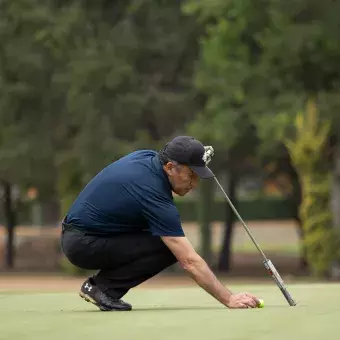 Jugador posicionando la pelota en el green