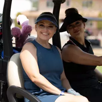 Golfistas mujeres sonriendo en un carro del golf